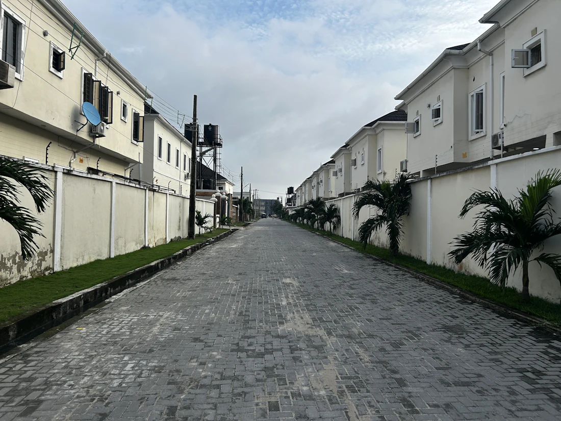 A gated estate of family homes on a paved street in Lagos, Nigeria